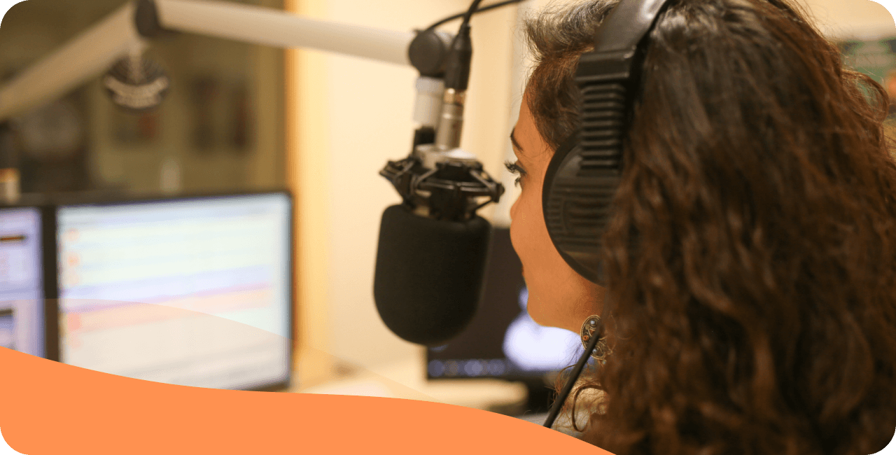 Woman broadcasting live in a radio studio with a microphone and headphones