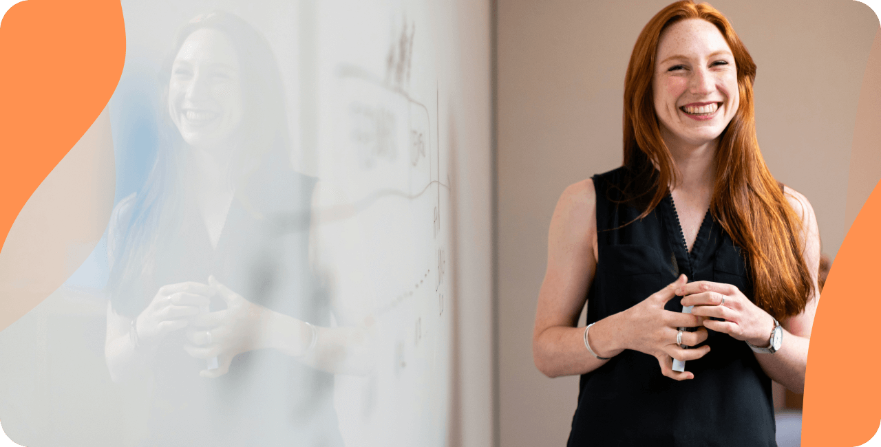 Woman smiling next to a white board